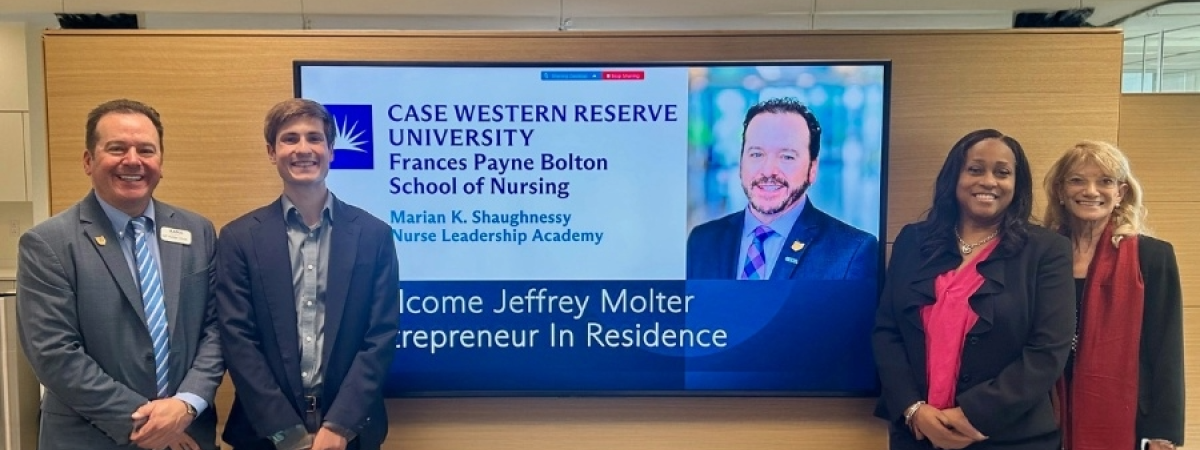 Jeffrey Molter standing next to a digital screen 