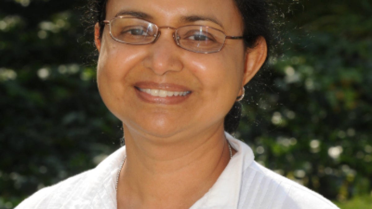 Suchitra Nelson, PhD poses in a white shirt.