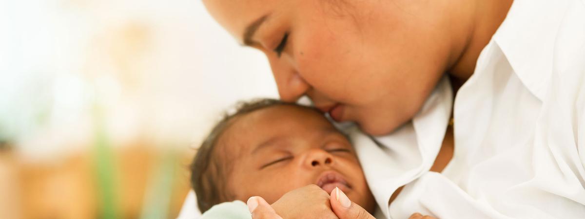 Close up photo of a mother kissing her baby's head