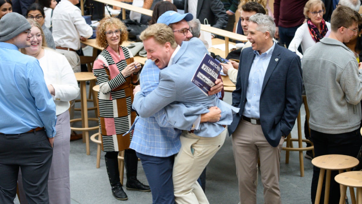 two students hugging as they open their match day envelopes