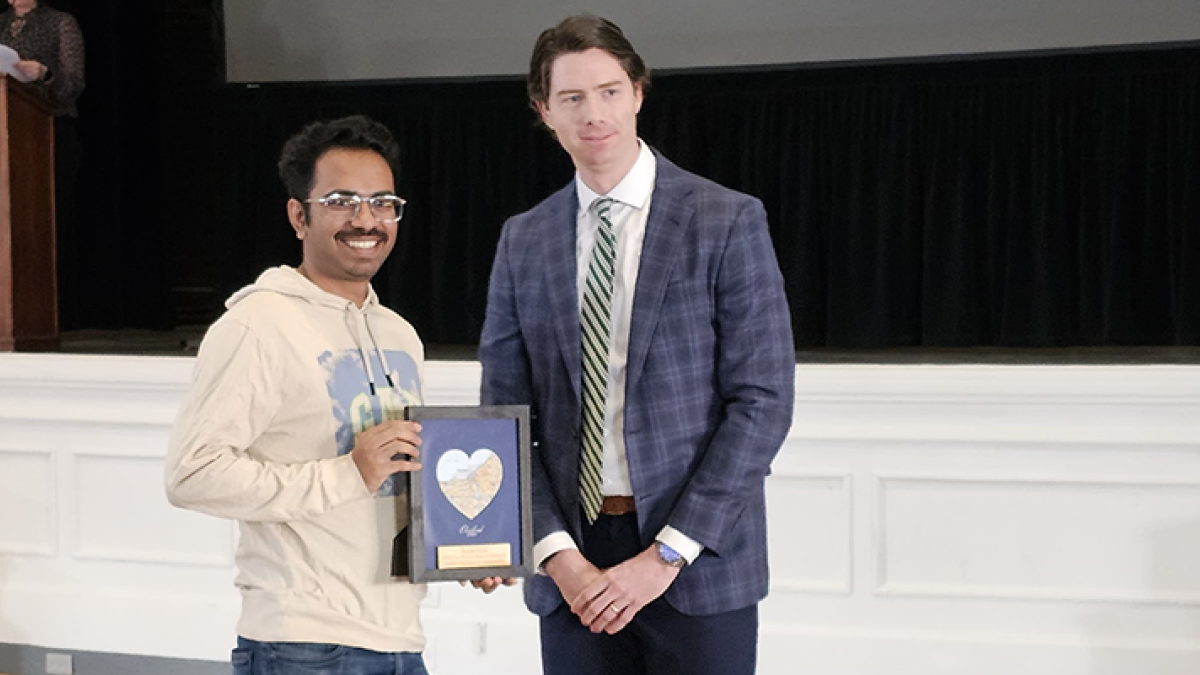 Image of Rishabh Kundu holding an award next to Tim Dengler