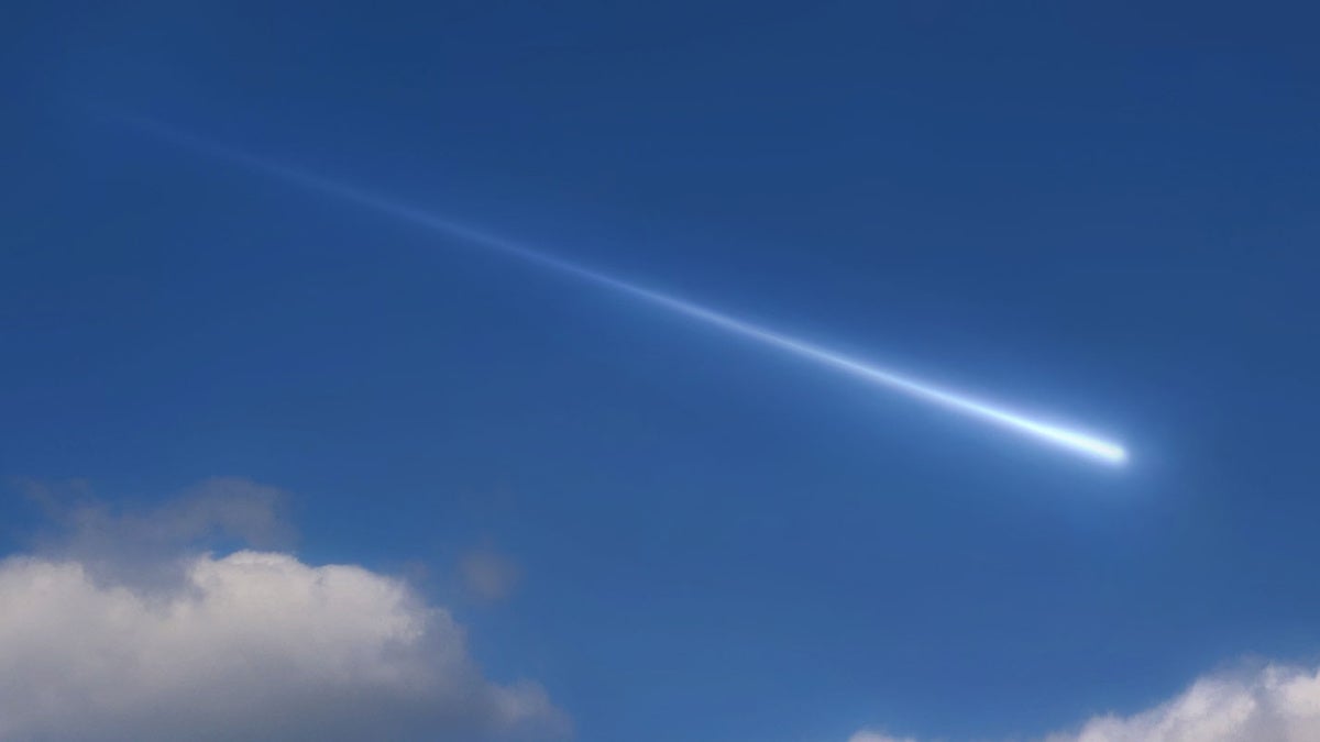 Photo of a meteor streaking across a blue sky