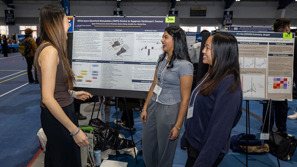 Photo of students presenting a poster at Intersections in fall 2025