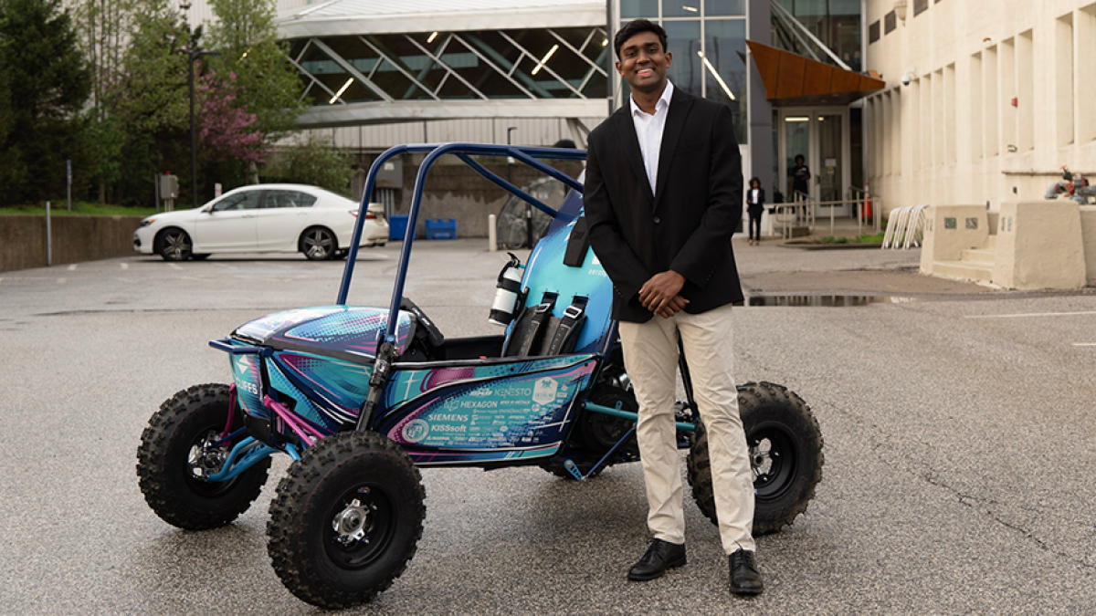 Photo of Auston Govender with a Baja SAE car