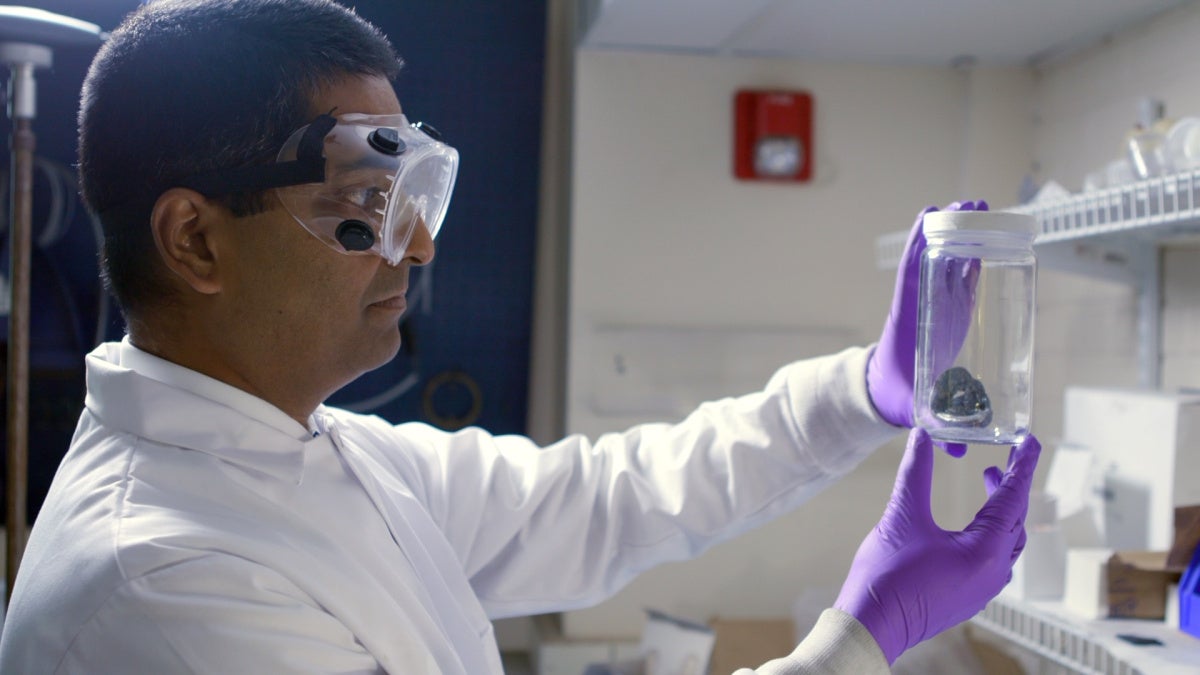Professor Rohan Akolkar looking at a jar