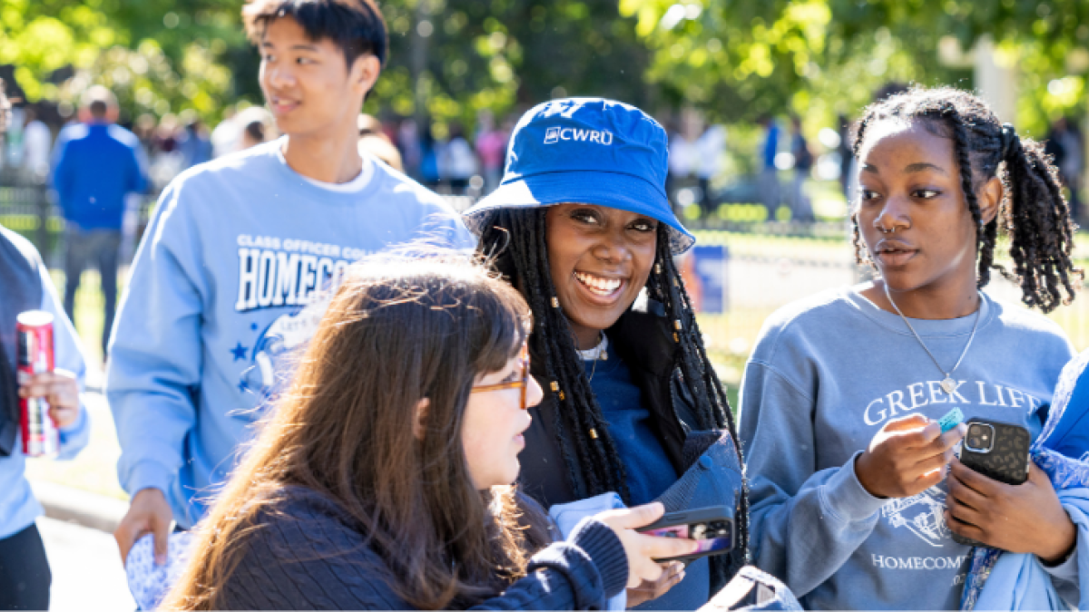 Students on campus, one wearing a Greek Life sweatshirt