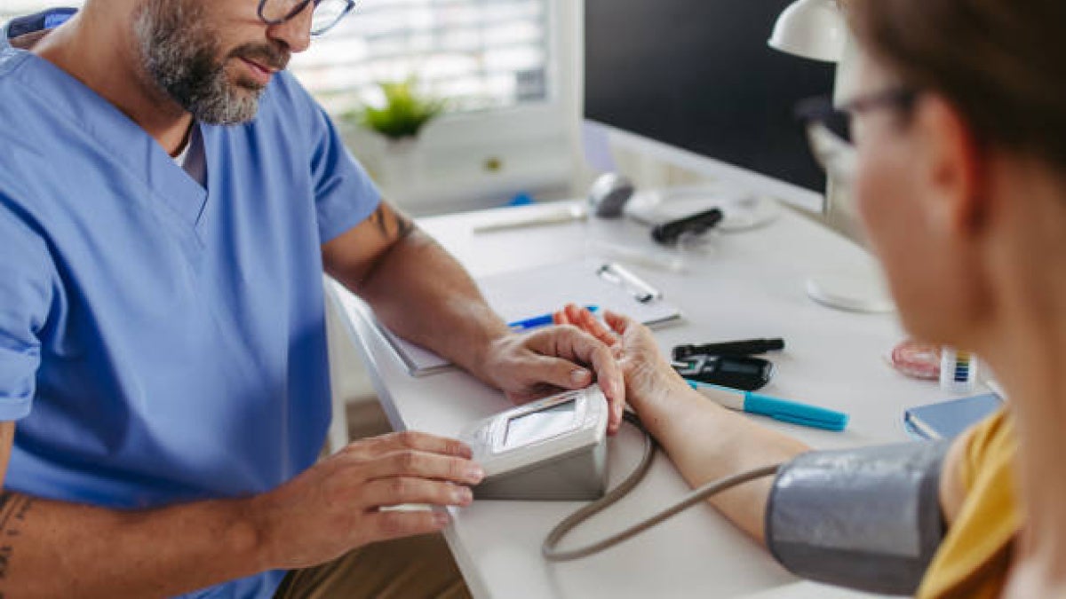 Image of a doctor recording patient's cholesterol levels