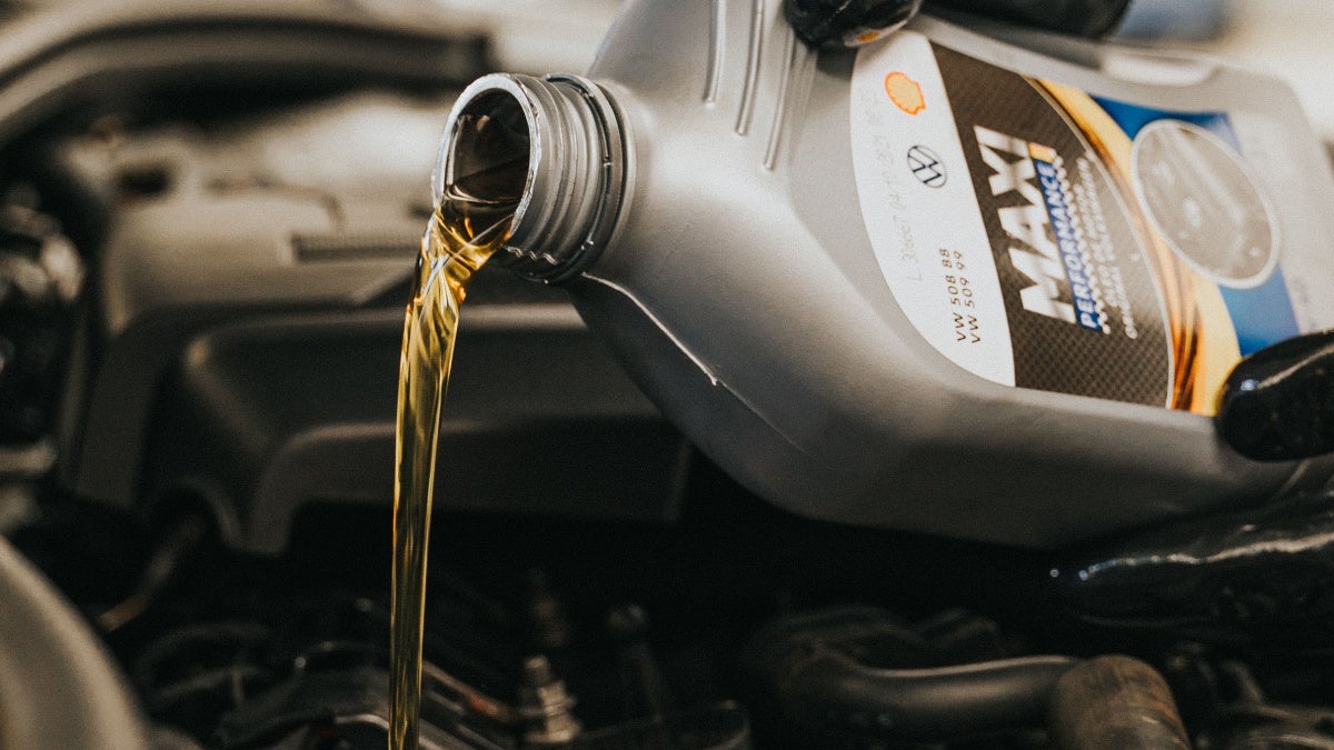 Image of motor oil pouring in car's engine compartment