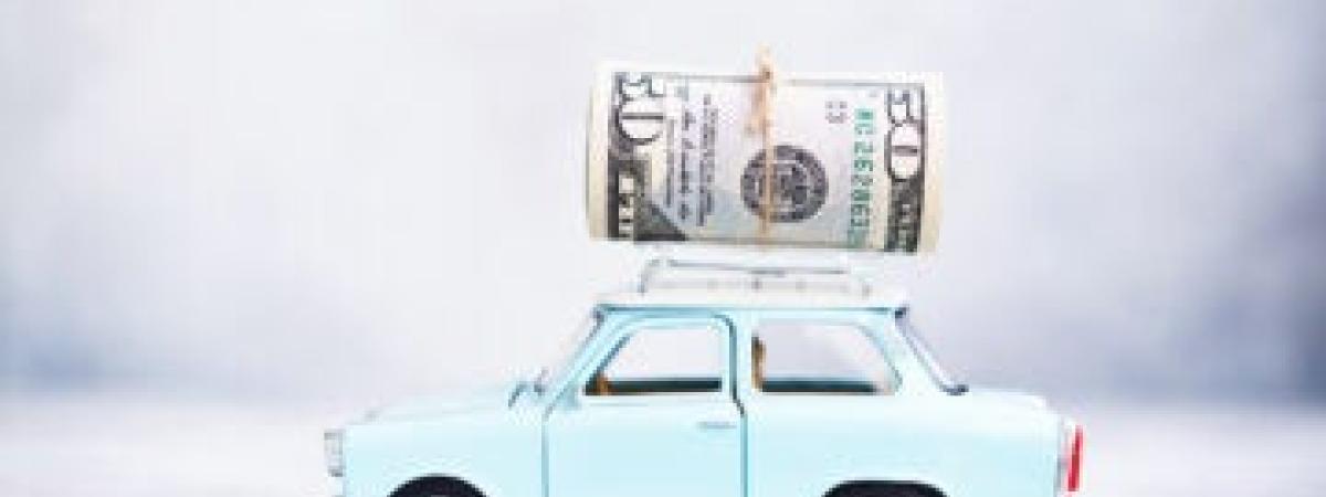 Money on top of small blue car