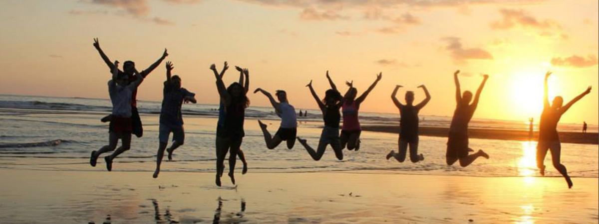 students-jumping-beach