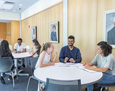 Two tables of students in Mandel Center talking