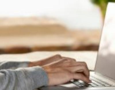 Hands typing on a laptop