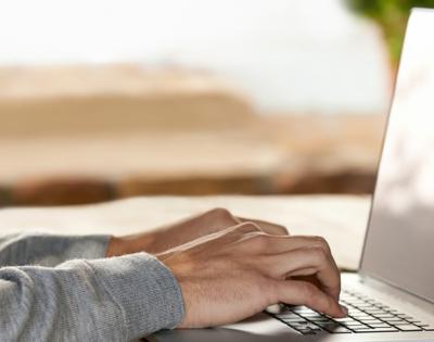 Close up photo of hands typing on laptop
