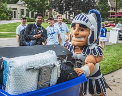 Spartie pushes a luggage cart during move-in