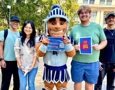 Photo of CWRU students posing with Spartie with anti-hazing signage
