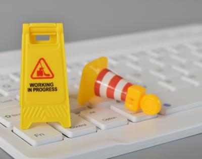 Mini "Work in progress" and construction signs on computer keyboard.
