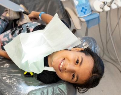 Young student smiles from the dental chair.