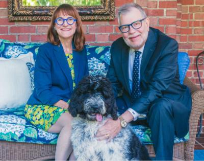 President Kaler and Mrs. Kaler pose for a photo on their porch with their dog