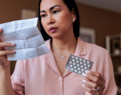 woman reading package insert of hormone replacement therapy medication