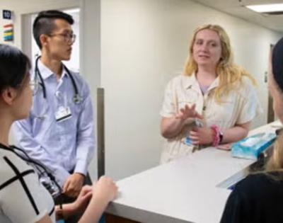 Residents talk around a hospital desk