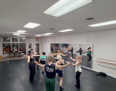 Photo of dancers gathered in a circle during a rehearsal