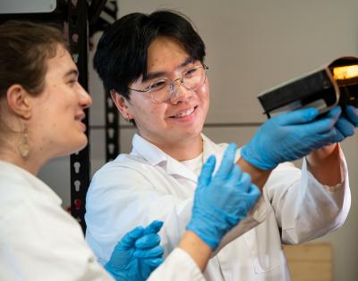 Photo of two CLEANR employees looking at a 3D printer part