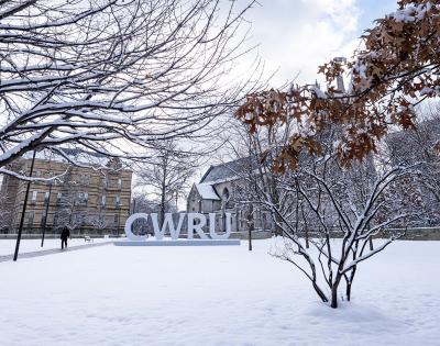Photo of the CWRU letters on campus surrounded by snow
