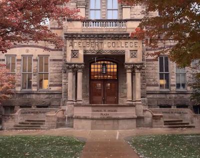 Adelbert Hall surrounded by red fall foliage with a light layer of snow. 