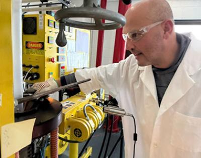 João Maia in a lab coat and safety glasses, working in his lab.