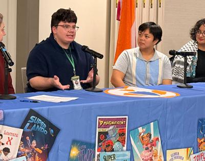 Photo of three CWRU students and Lisa Kollins speaking about a new art display for The Superhero Project