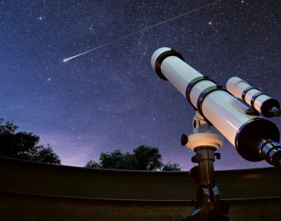 Telescope points to starry night sky
