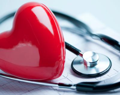 plastic heart laying on top of medical records next to a stethoscope