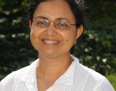 Suchitra Nelson, PhD poses in a white shirt.
