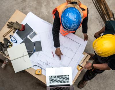 Two architects examine a blueprint.