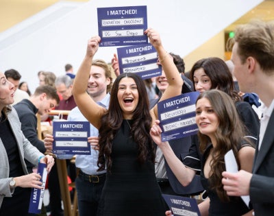 students holding up signs that read "I matched!"