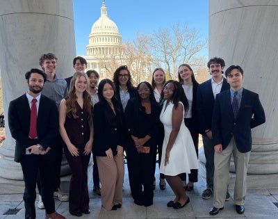Participants of the inaugural “Washington, D.C. Trek: Exploring the Political Ecosystem and Career Paths” course pose for a group photo in front of the United States Capitol building. 