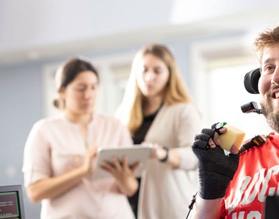 Photo of a man with quadriplegia holding an item with the help of a brain-computer interface
