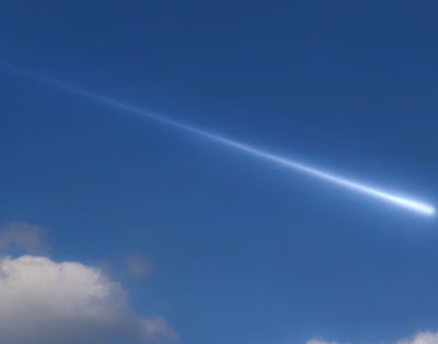 Photo of a meteor streaking across a blue sky