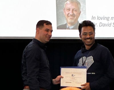 Photo of Rishab Kundu accepts award at conference