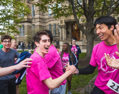 Students celebrate after the Hudson Relays while wearing bright pink shirts