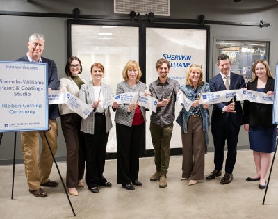 People stand for a ribbon cutting of the new Sherwin-Williams Paint and Coatings Studio in think[box]