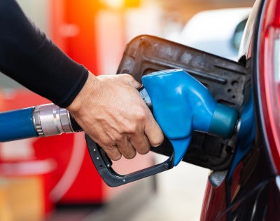 A person fills their car with gas
