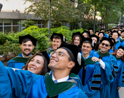 2026 MD students taking a selfie while lining up for commencement