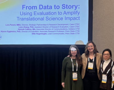 Four women standing in front of a presentation screen