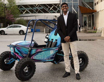 Photo of Auston Govender with a Baja SAE car