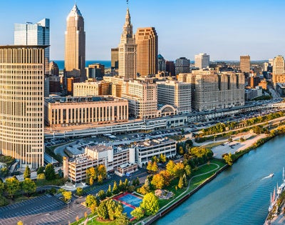 Photo of the Cleveland skyline on a bright sunny day with the Cuyahoga River in the foreground