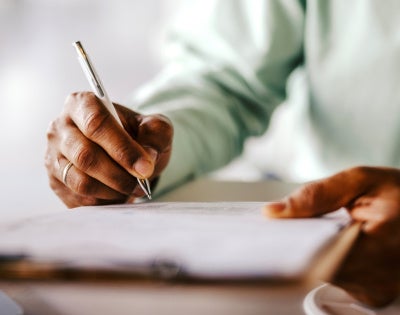 Close up of a person signing paperwork
