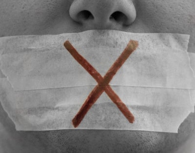 Close-up of face with tape over mouth and "X" drawn on it