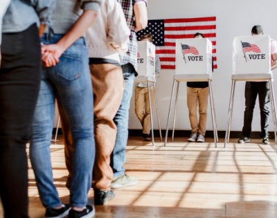 People in line wait at voting booths