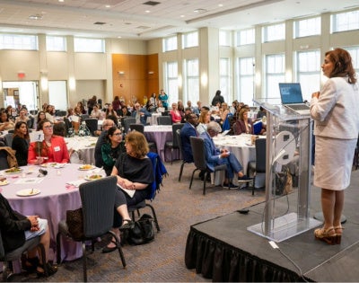 faculty attendees at round tables listening to a speaker at the WFSOM dinner